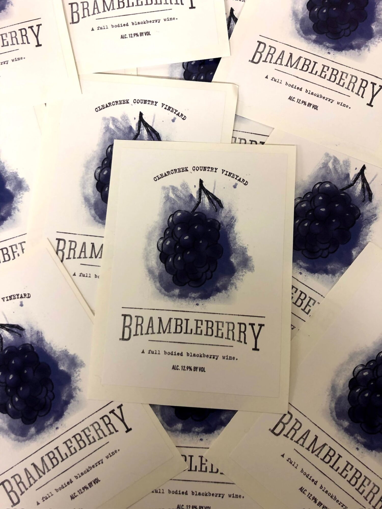 Multiple white packets with black and purple raspberry illustrations and text, scattered randomly.