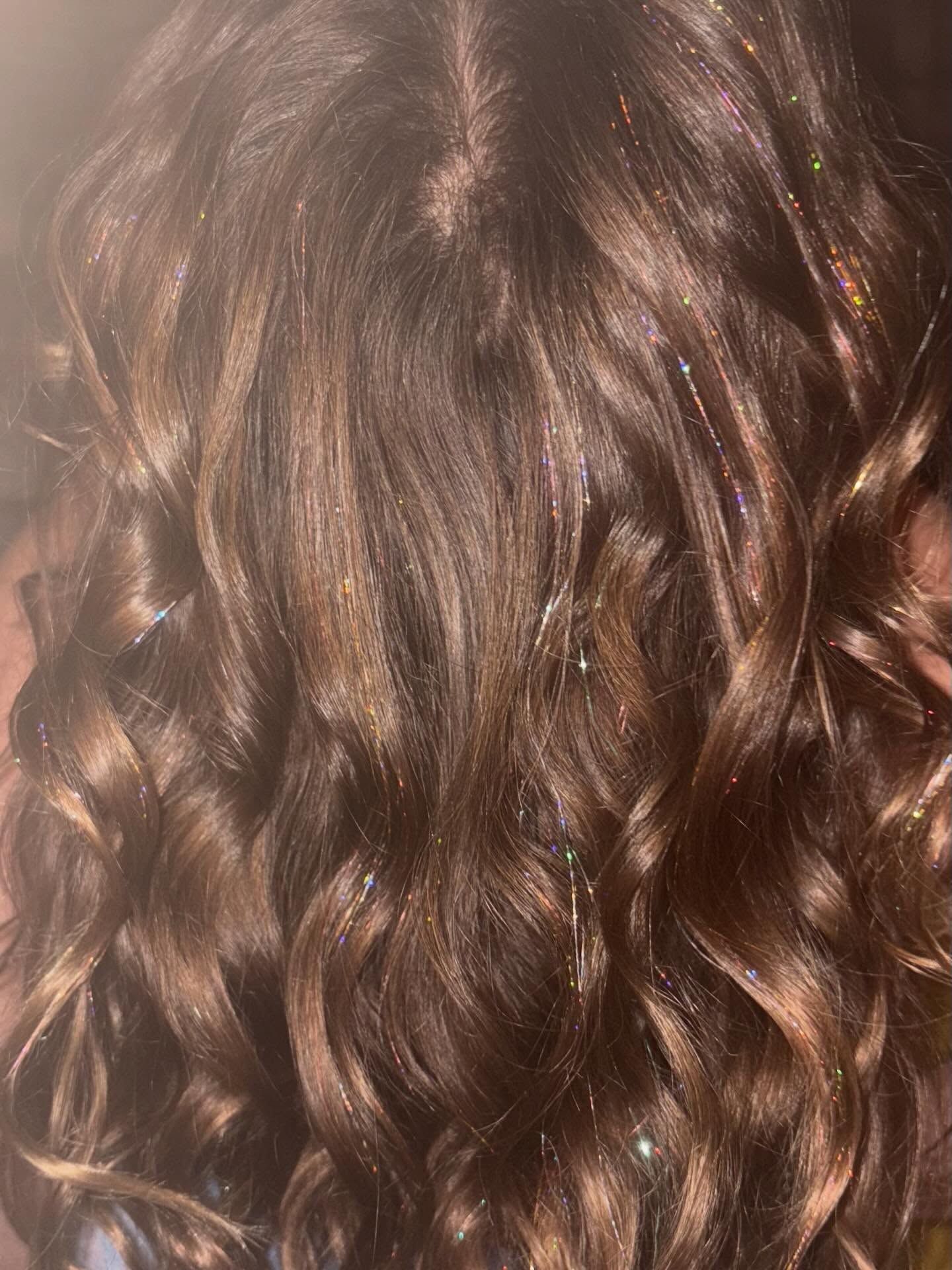 Close-up of wavy brown hair with subtle highlights and shine.