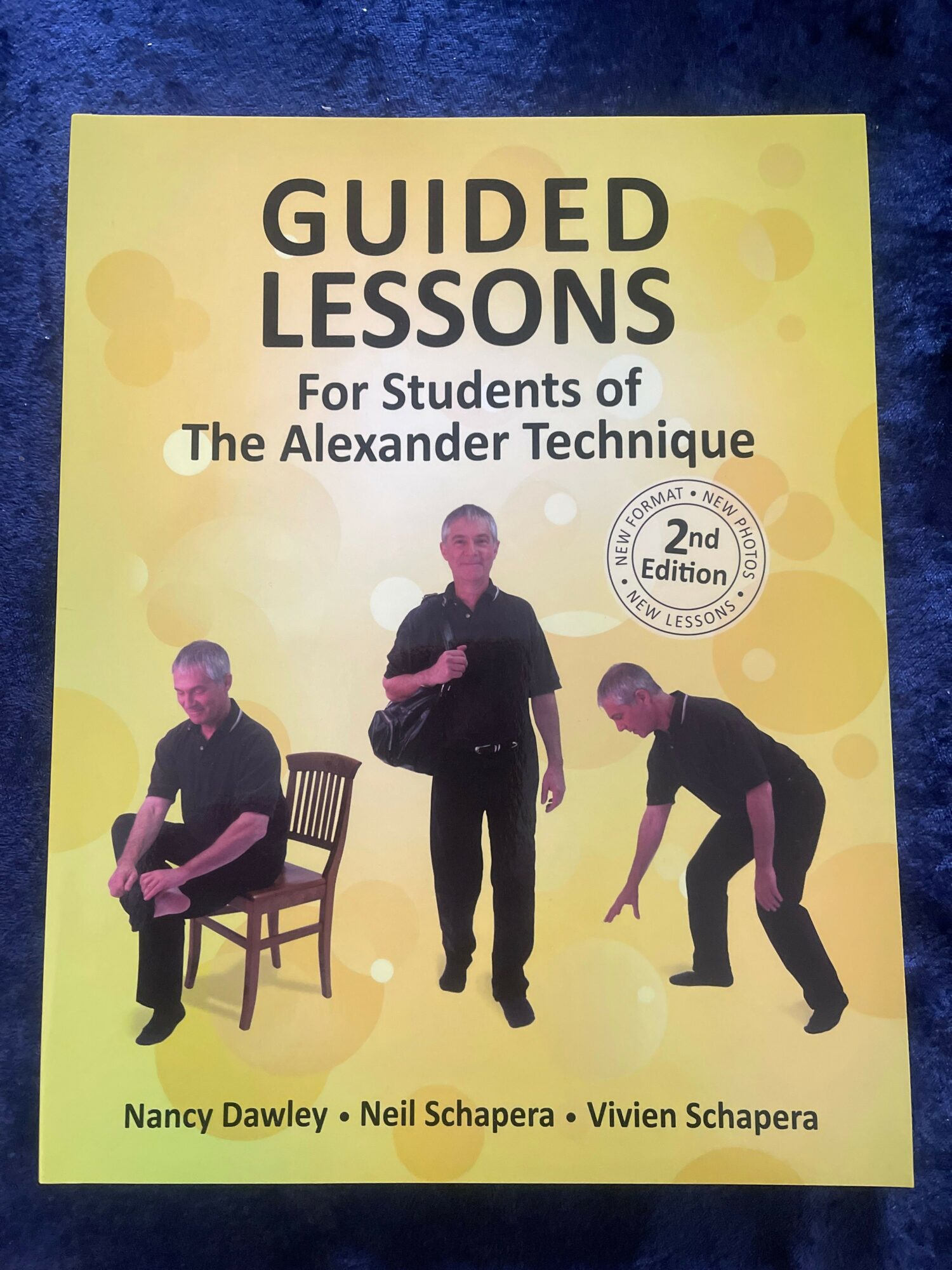 Yellow book cover titled 'Guided Lessons for Students of The Alexander Technique' with three people demonstrating techniques.