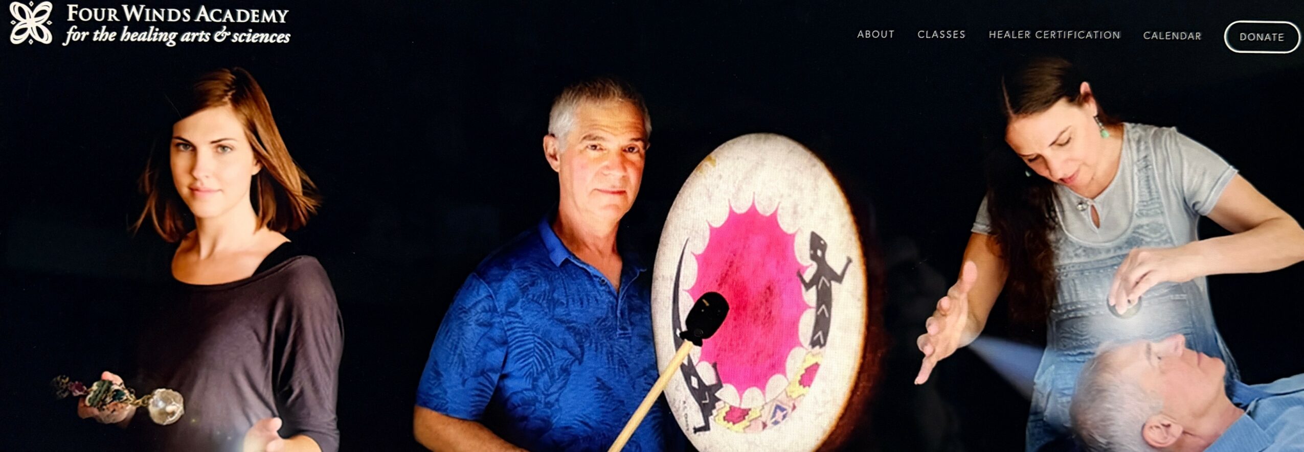 Three people stand in front of a dark background with a logo, holding objects, with a large pink and white circular object.