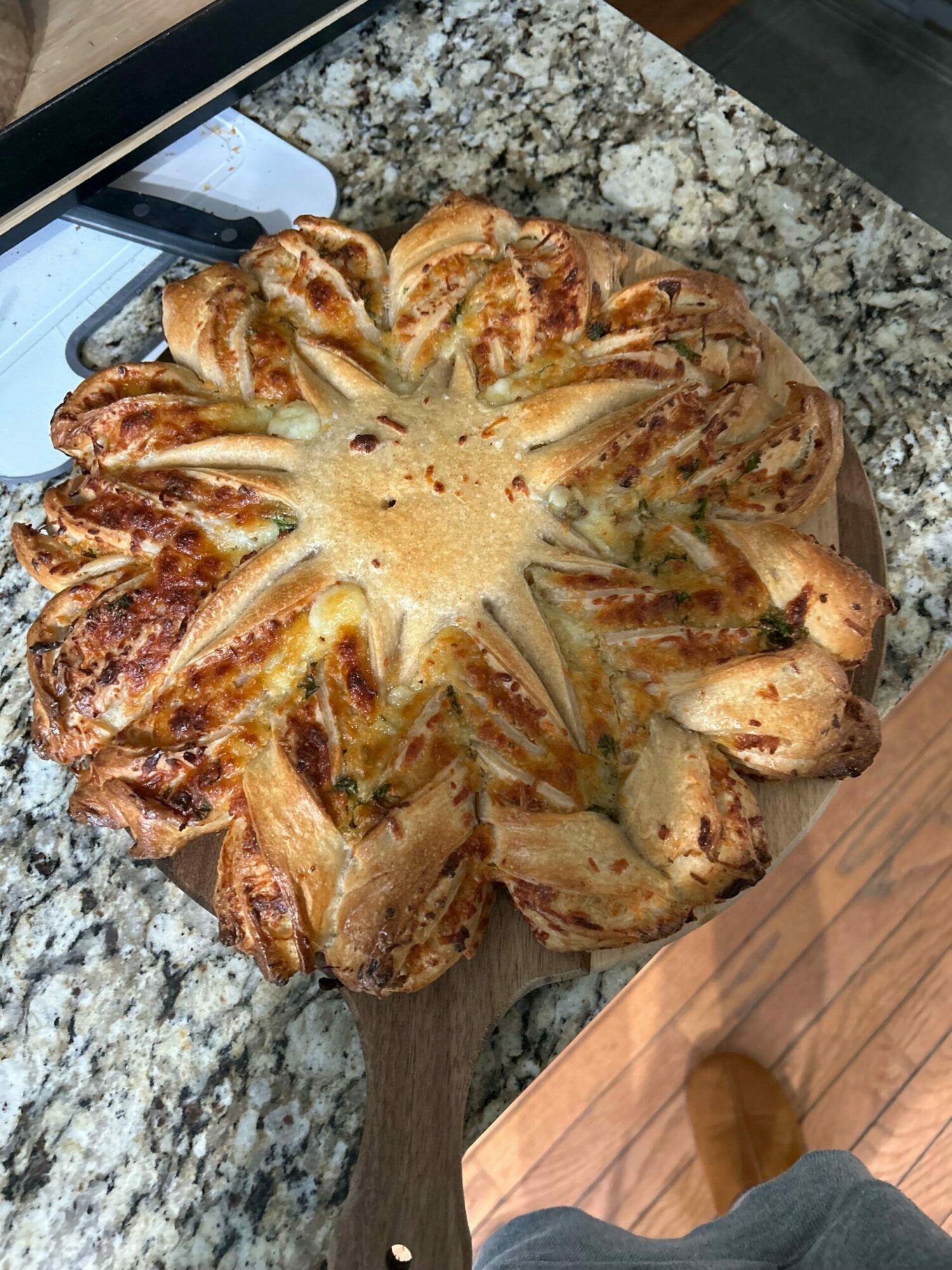 Star-shaped pastry with a golden-brown crust on a granite countertop, partially visible knife nearby.