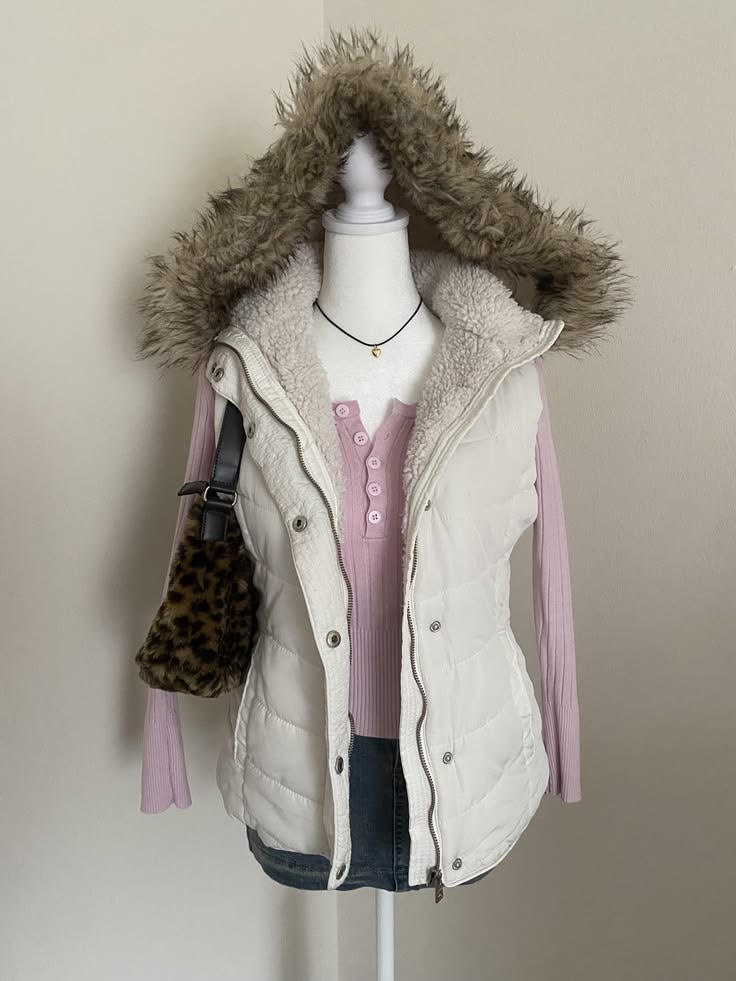 Mannequin dressed in a pink long-sleeve top, white vest with fur-lined hood, and a leopard print bag.