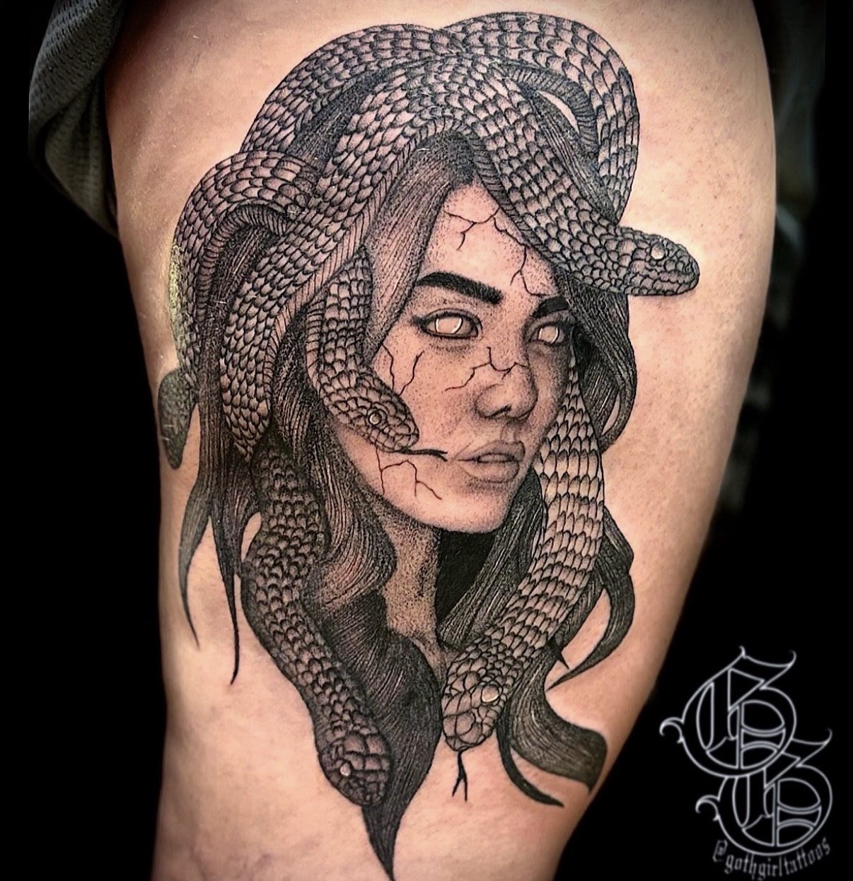 Tattoo of a woman with snakes in her hair, detailed shading, on skin. Black and gray ink. Confident expression.