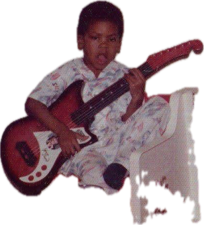 Child sitting on a white chair, holding a guitar, wearing pajamas, against a black background.