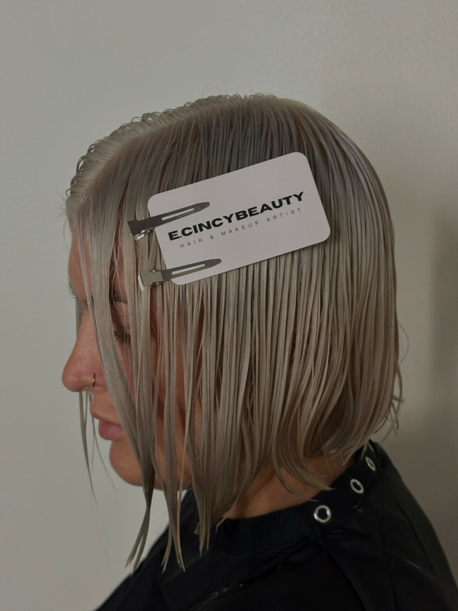 Side view of a person with wet, blonde hair, holding a tag labeled 'ECINCYBEAUTY' on their head.
