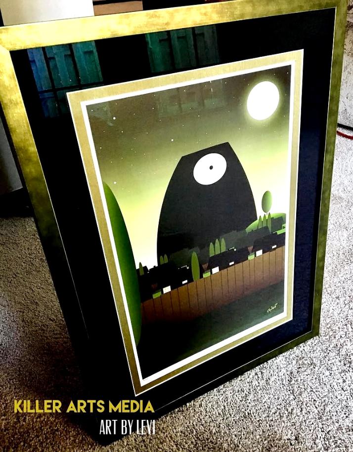Framed artwork featuring a black creature with a white eye, green background, moon, and trees, with text at the bottom.