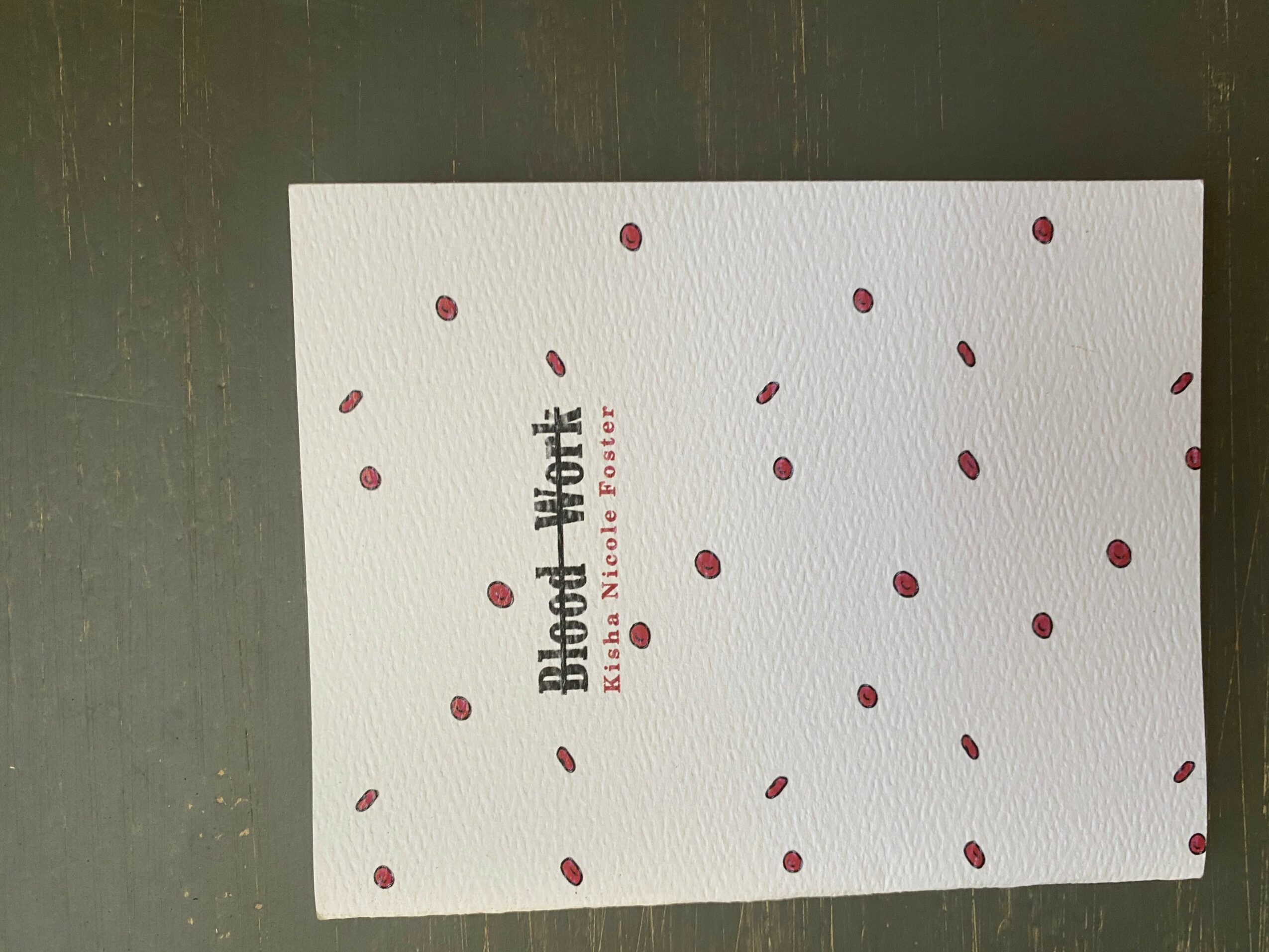 White card with red and purple dots, text in the center, on a dark surface.