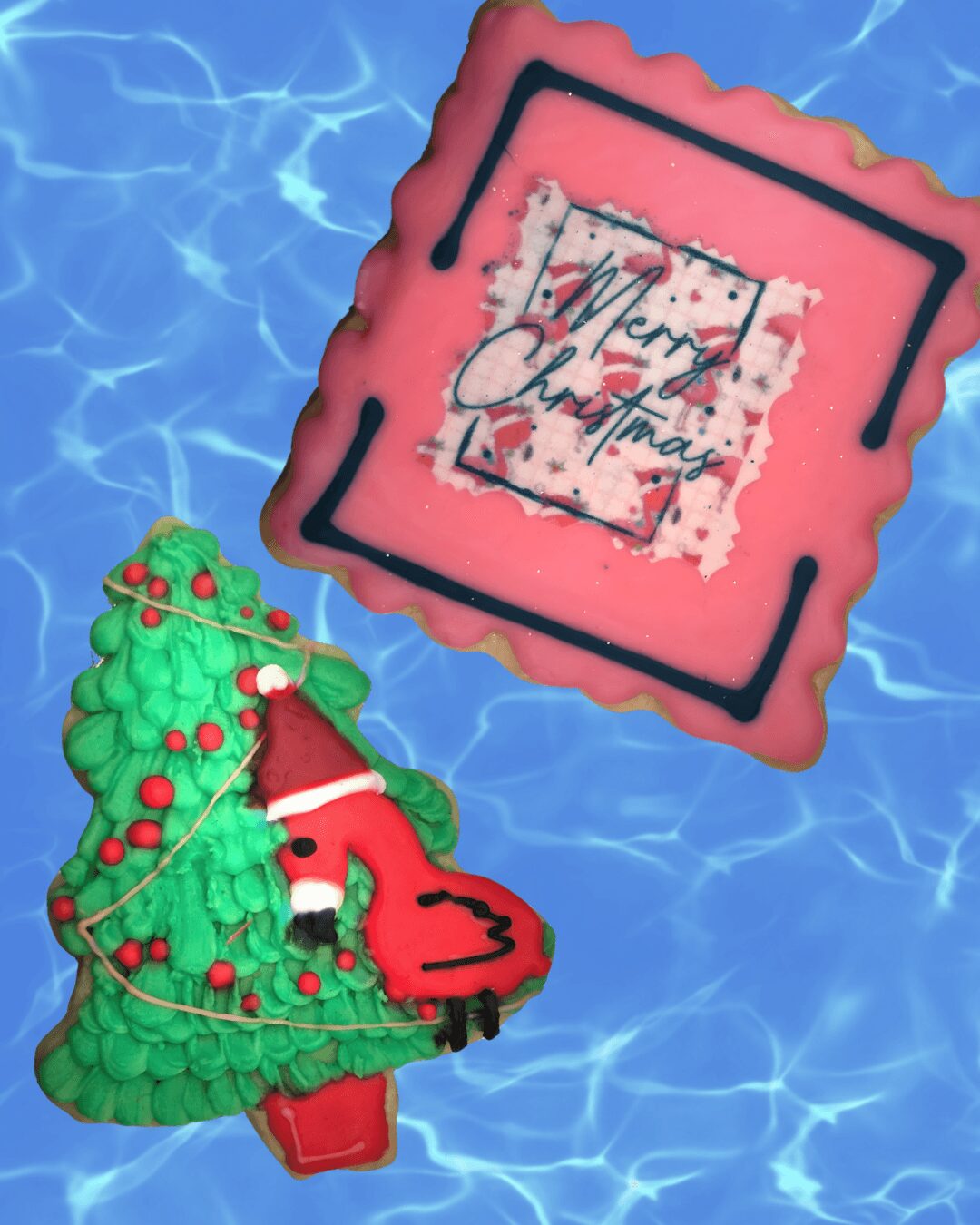 Decorative Christmas cake with a Christmas tree and a Santa figure, on a blue water background, with a holiday message.