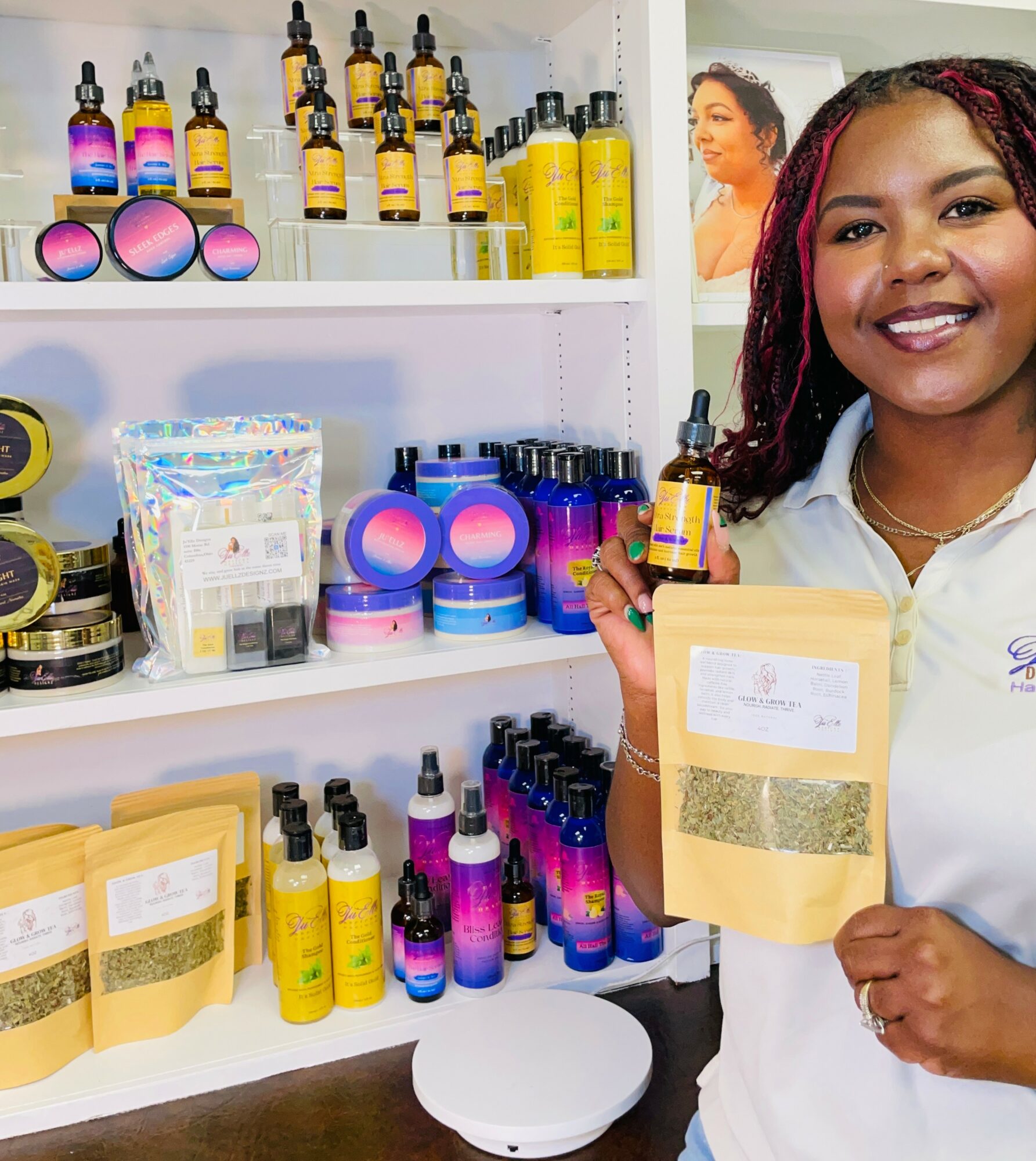 Smiling woman holding a product in a store with shelves of skincare and beauty products behind her.