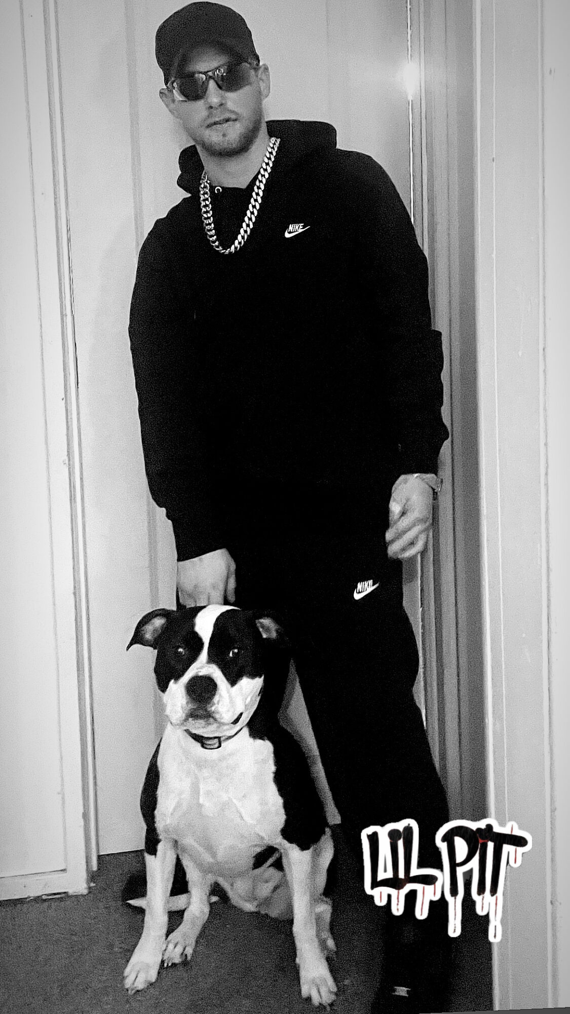 Man wearing sunglasses, cap, and chain stands next to a smiling dog in front of a door, with Lil Pump logo.