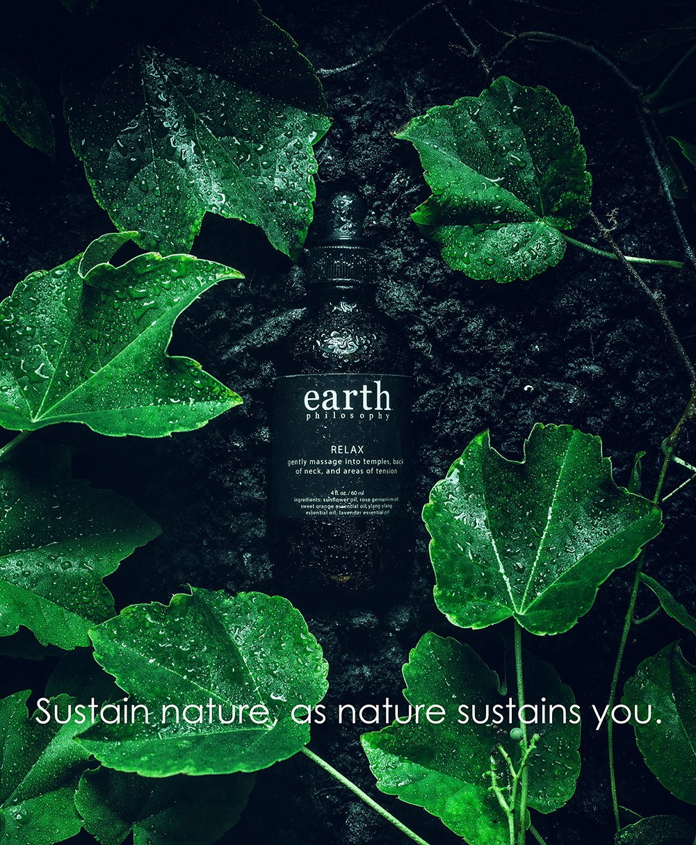 Dark background with green leaves and water droplets, text about earth and sustainability, and a quote about nature.