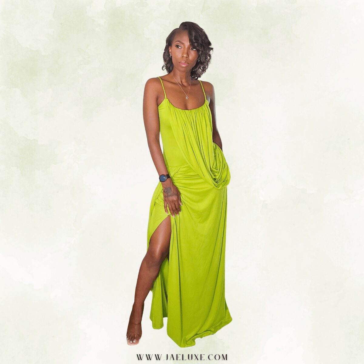 Woman in a bright green dress with spaghetti straps, standing against a plain background, looking to the side.
