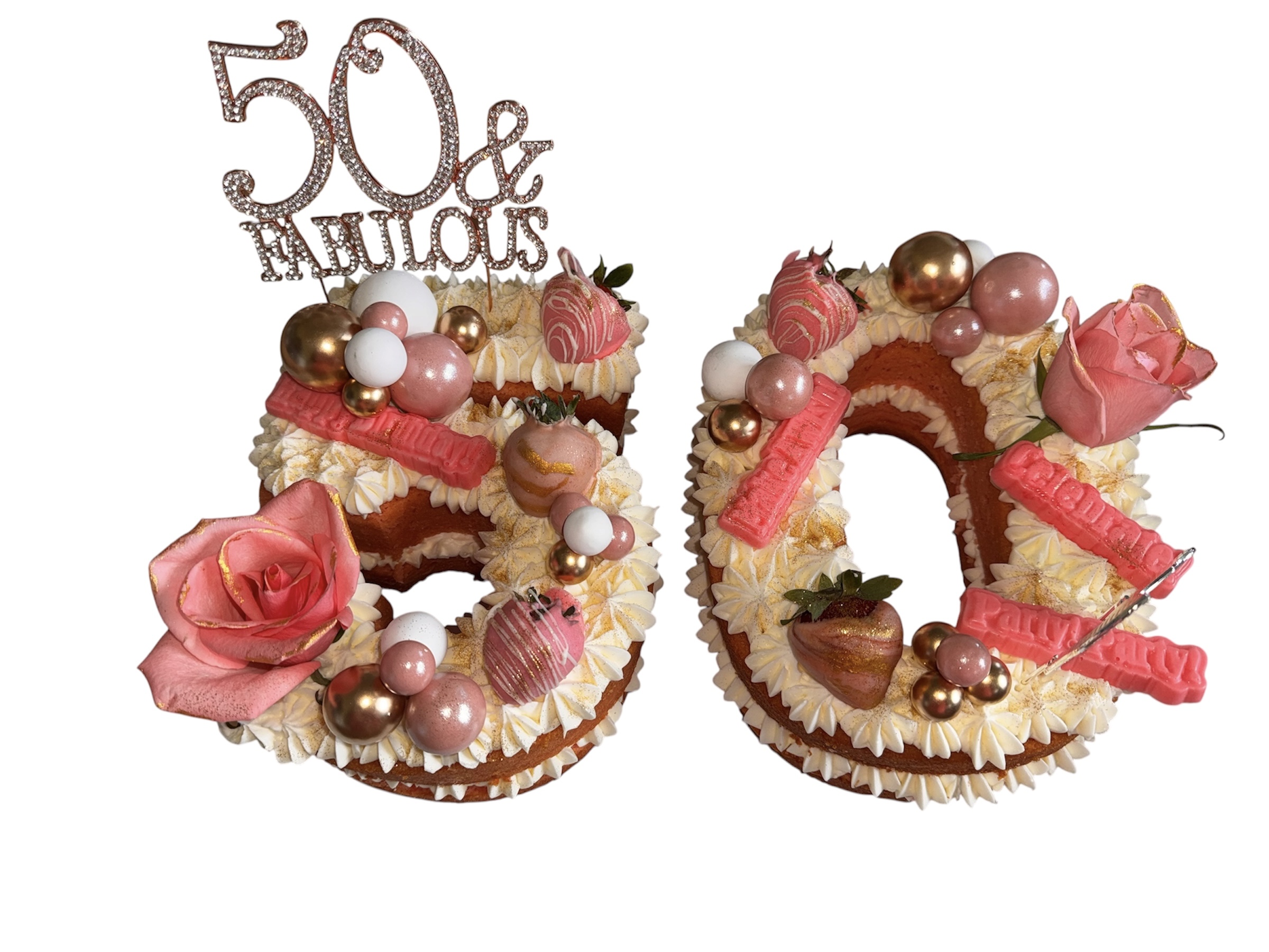 Number 50 cake decorated with pink roses, chocolates, and pink and white candies, celebrating a 50th anniversary or birthday.