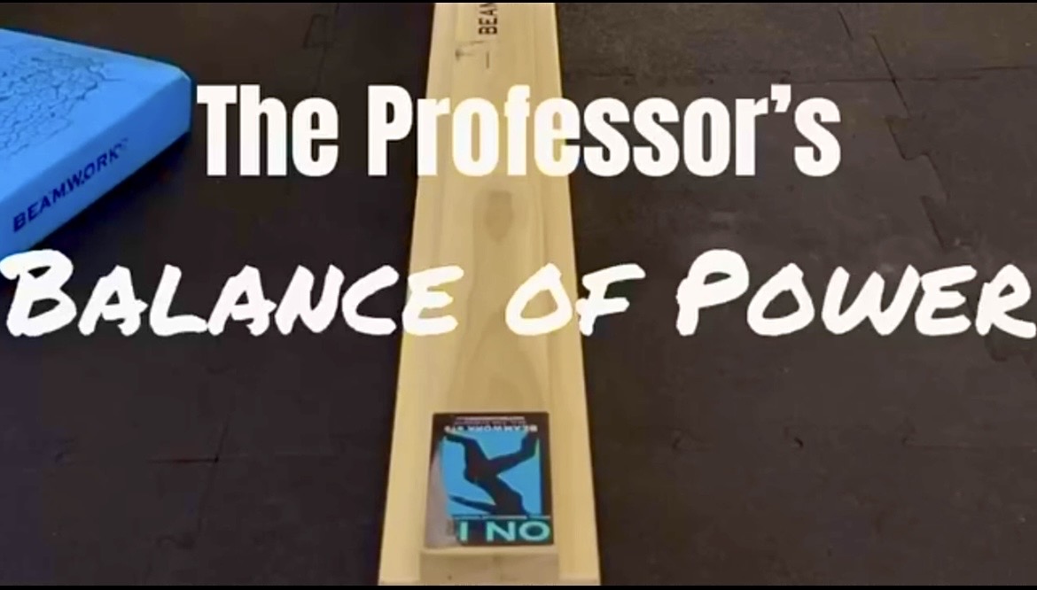 A wooden balance beam with a phone displaying a person falling, and text reading 'The Professor's Balance of Power'.