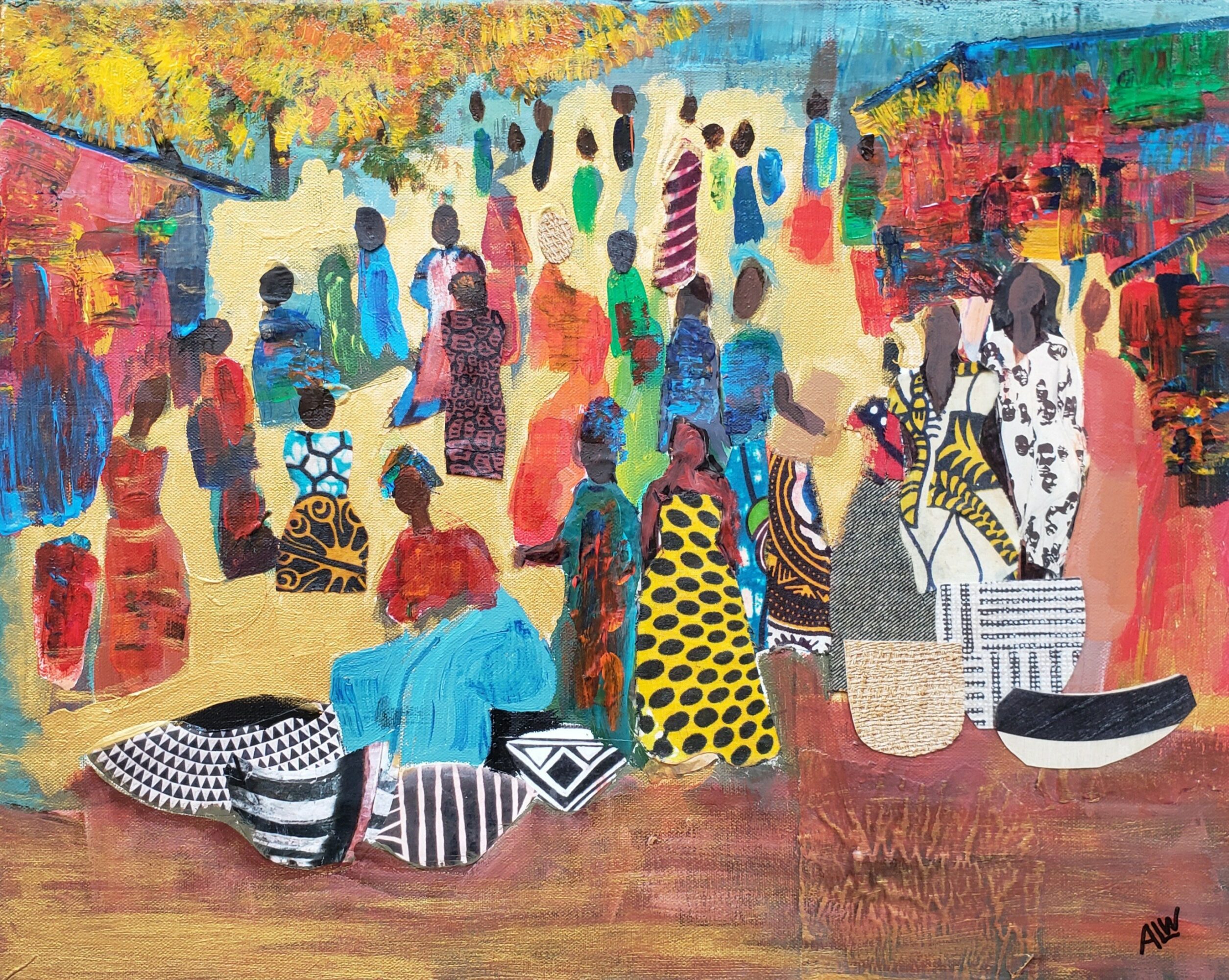 Group of people gathered outdoors, some sitting on the ground with bags, others standing, colorful clothing, trees in background.