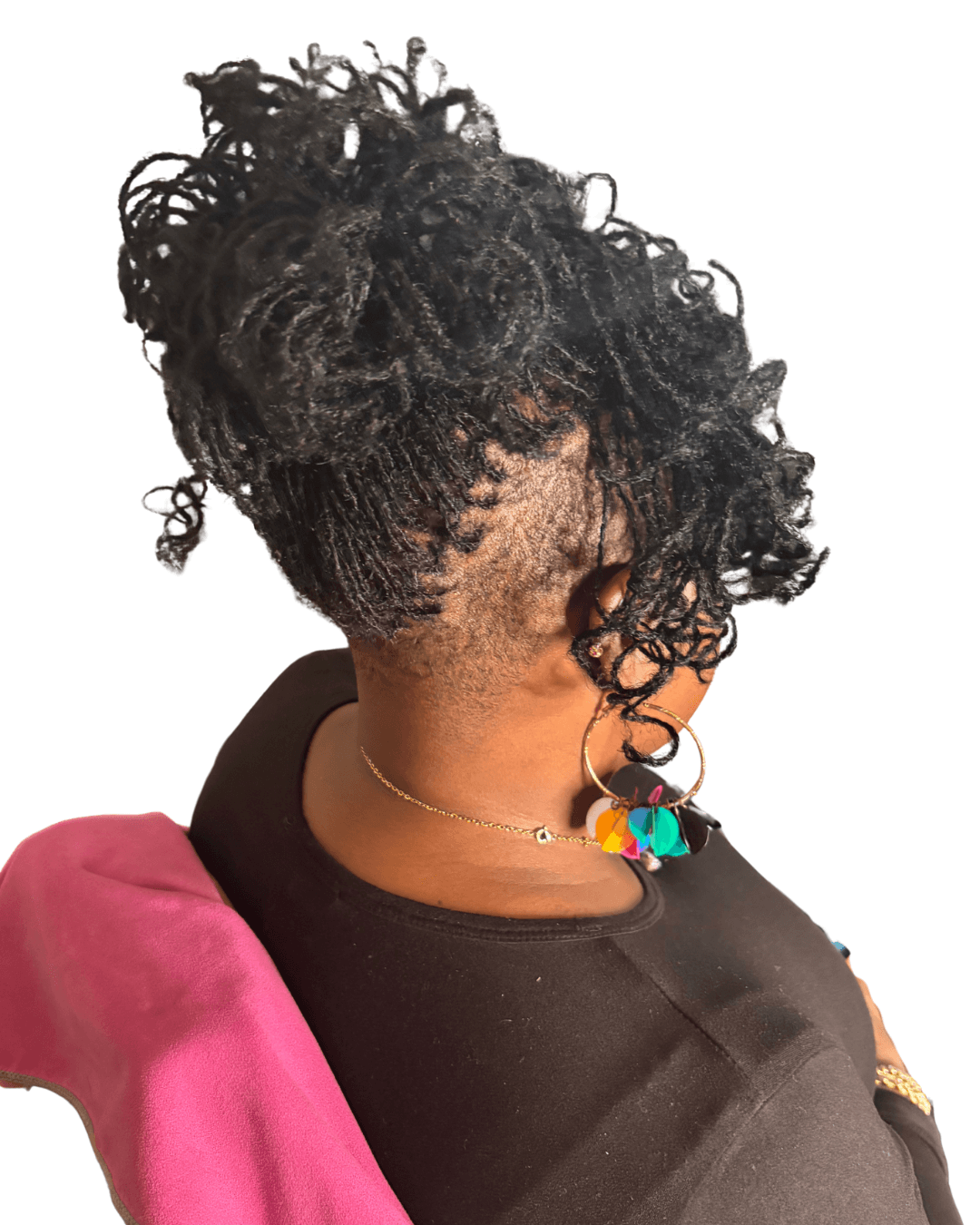Person with curly hair styled in an updo, wearing a black top and colorful earrings, facing away from the camera.