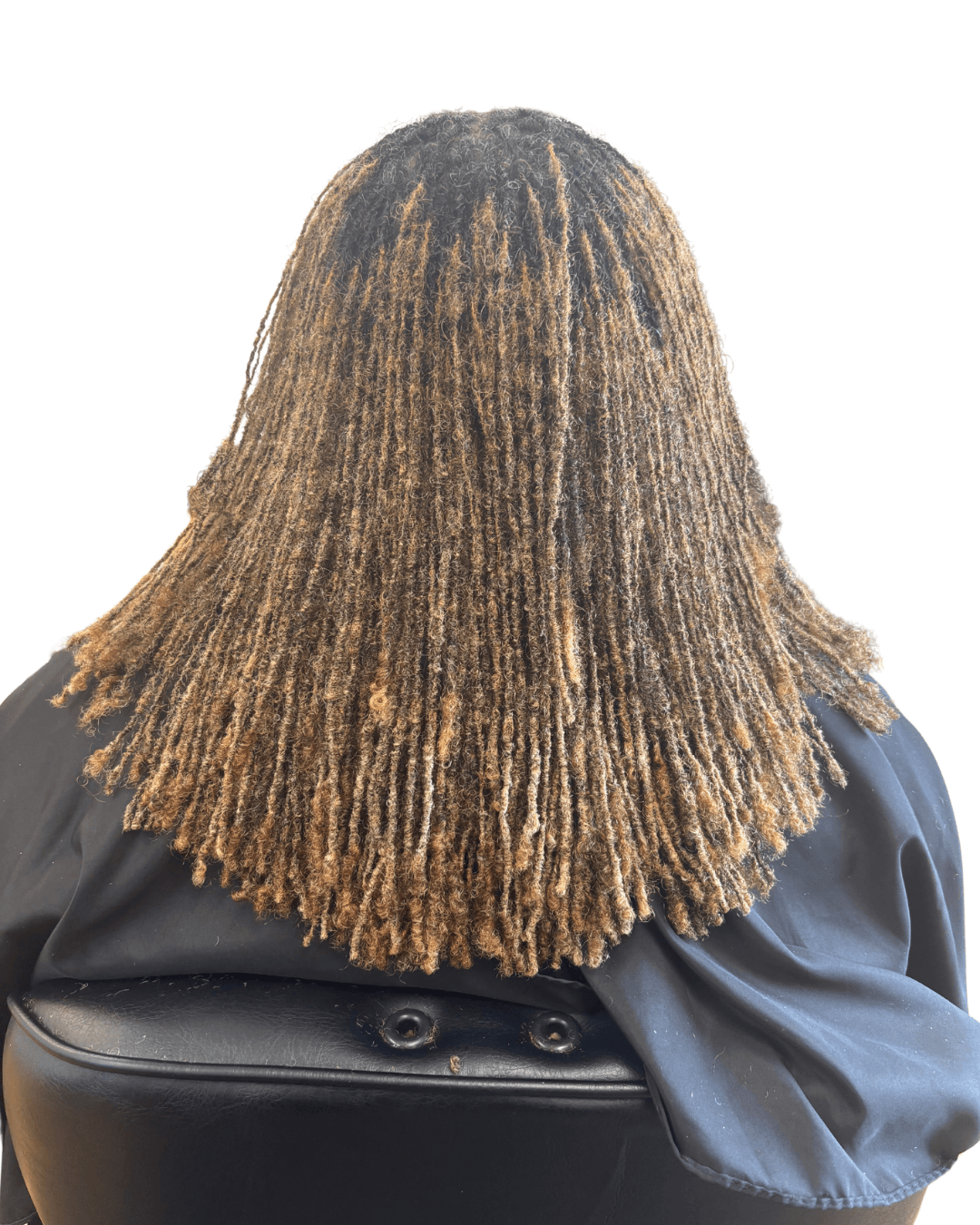 Back view of a person with shoulder-length, textured, light brown hair, wearing a dark jacket, seated on a black chair.